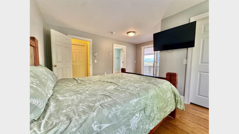 Image of Main Bedroom looking from the corner towards the hallway, bathroom, and view