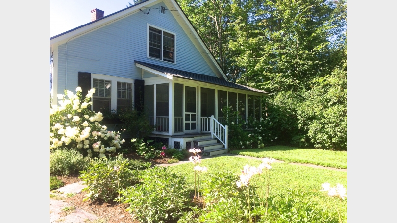 Cottage front with wrap-around screened porch